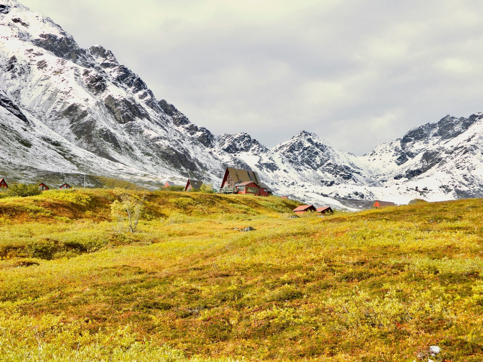 Alaska mountain landscape with a small lodge